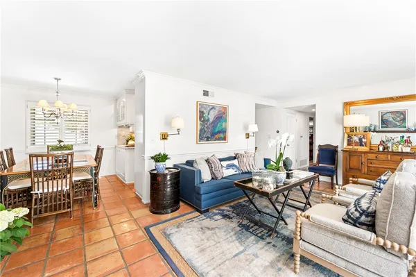 a living room with furniture a dining table and a floor to ceiling window