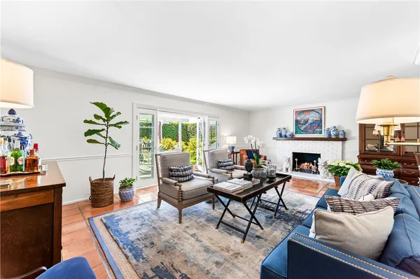 a living room with furniture a fireplace and a potted plant