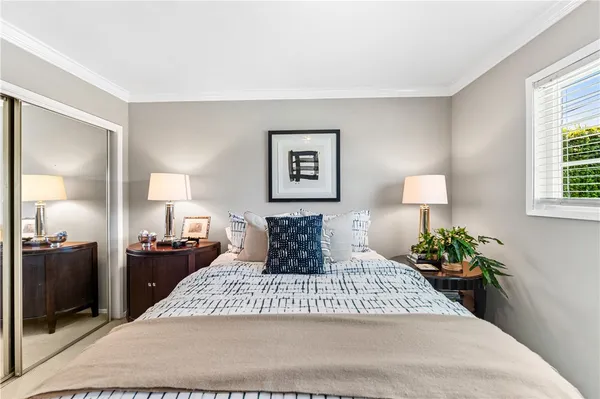 a bedroom with a bed a lamp and a large window