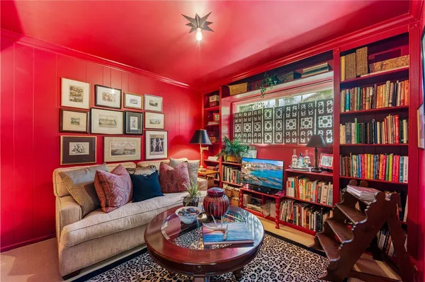 a living room with furniture a bookshelf and a large window