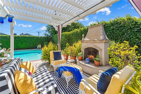 a view of a patio with table and chairs potted plants and large tree