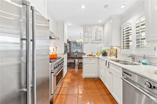 a kitchen with white cabinets and appliances
