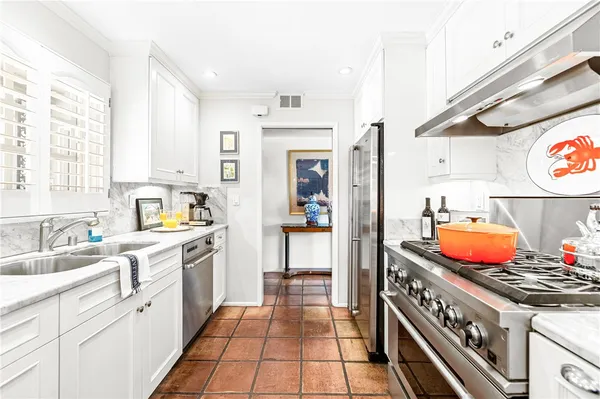 a kitchen with stainless steel appliances a stove a sink and a refrigerator