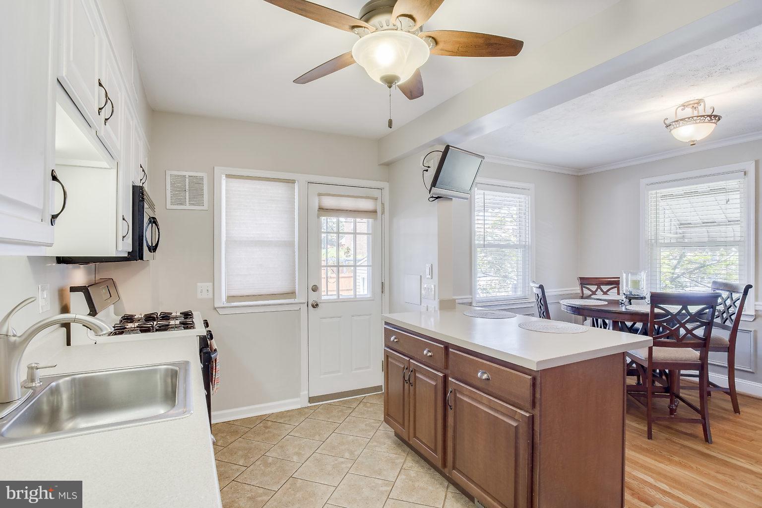 8626 Oak Road Baltimore, MD 21234 - Photo 14 of 30 a room with a sink dishwasher a dining table and chairs with wooden floor