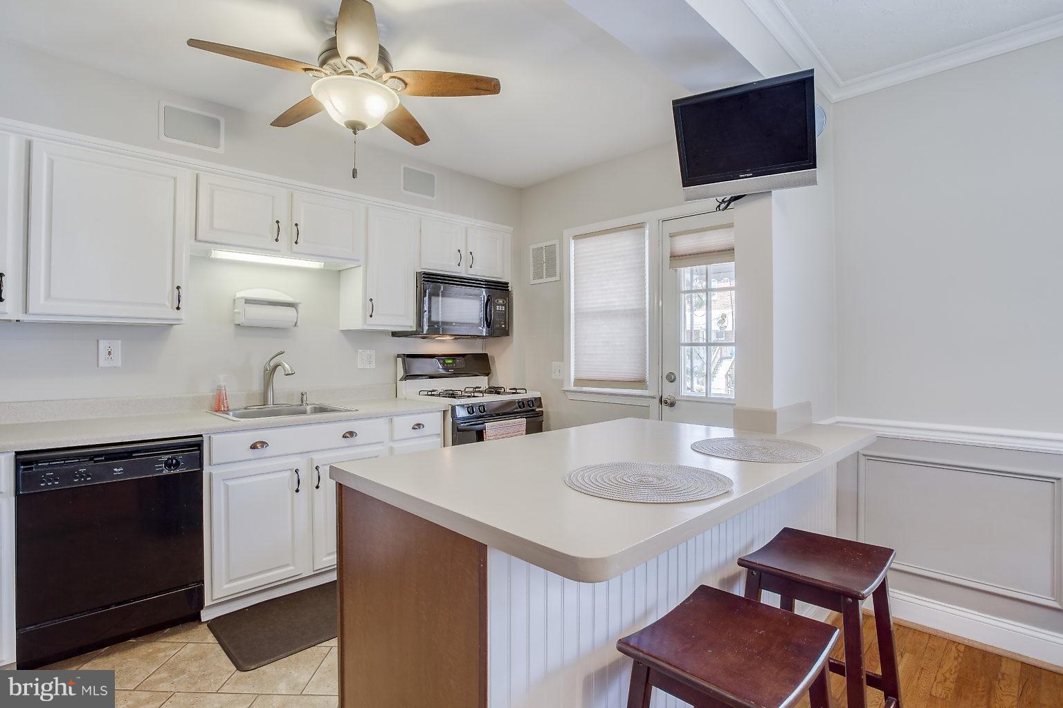 8626 Oak Road Baltimore, MD 21234 - Photo 16 of 30 a kitchen with a stove a sink and a microwave