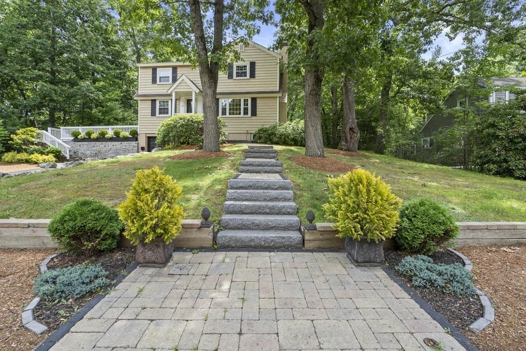 a front view of a house with a yard and potted plants