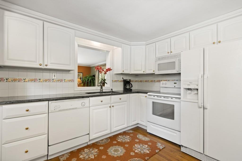 56 Ledgewood Road Dedham, MA 02026 - Photo 12 of 36 a kitchen with granite countertop white cabinets and white appliances