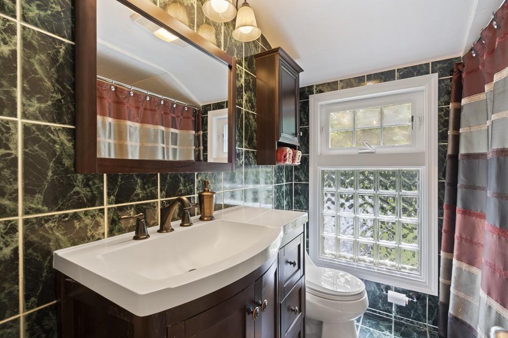 56 Ledgewood Road Dedham, MA 02026 - Photo 23 of 36 a bathroom with a sink vanity mirror and toilet