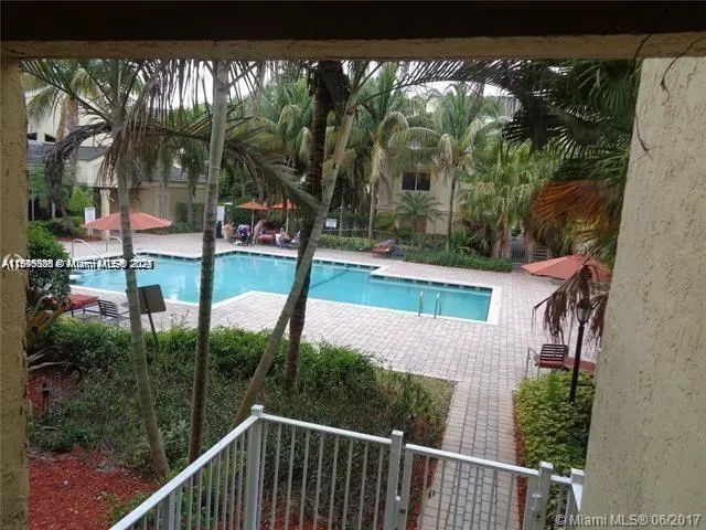 a patio with couple of table and chairs under an umbrella