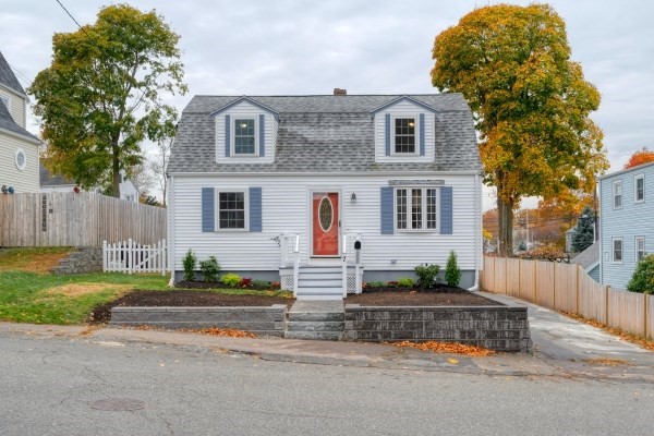 a front view of a house with a garden and parking