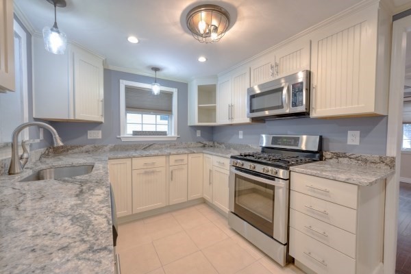 7 Weyham Road Weymouth, MA 02191 - Photo 4 of 38 a kitchen with stainless steel appliances granite countertop a stove a sink and a microwave