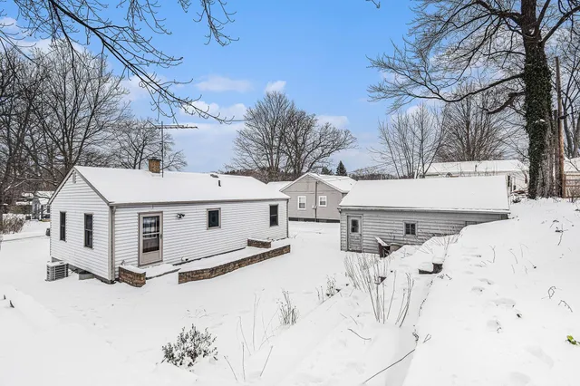 a view of a white house with snow on the road