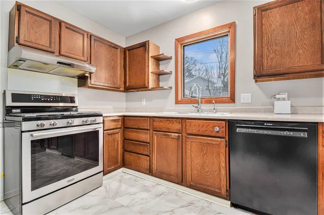 a kitchen with granite countertop cabinets stainless steel appliances and a sink