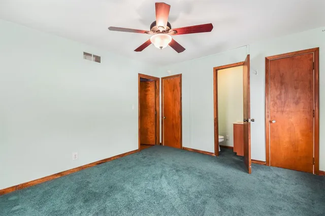 an empty room with closet and fan