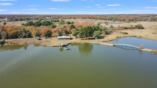 an aerial view of residential houses with outdoor space and lake view