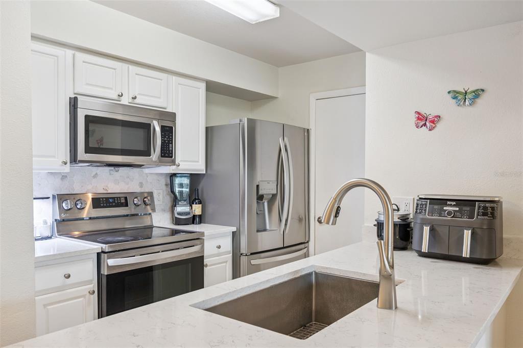 3032 Parkway Boulevard, Unit 305 Kissimmee, FL 34747 - Photo 11 of 40 a kitchen with granite countertop a stove and a microwave