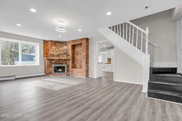 a view of wooden floor fire place and windows in a room