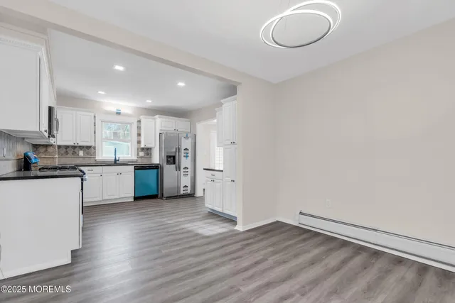 a view of kitchen with wooden floor and electronic appliances