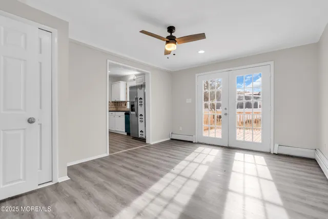 an empty room with wooden floor and windows