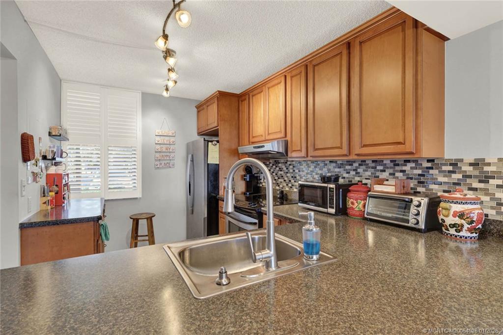 1950 Southwest Palm City Road, Unit 8106 Stuart, FL 34994 - Photo 10 of 54 a living room with furniture a flat screen tv and kitchen view