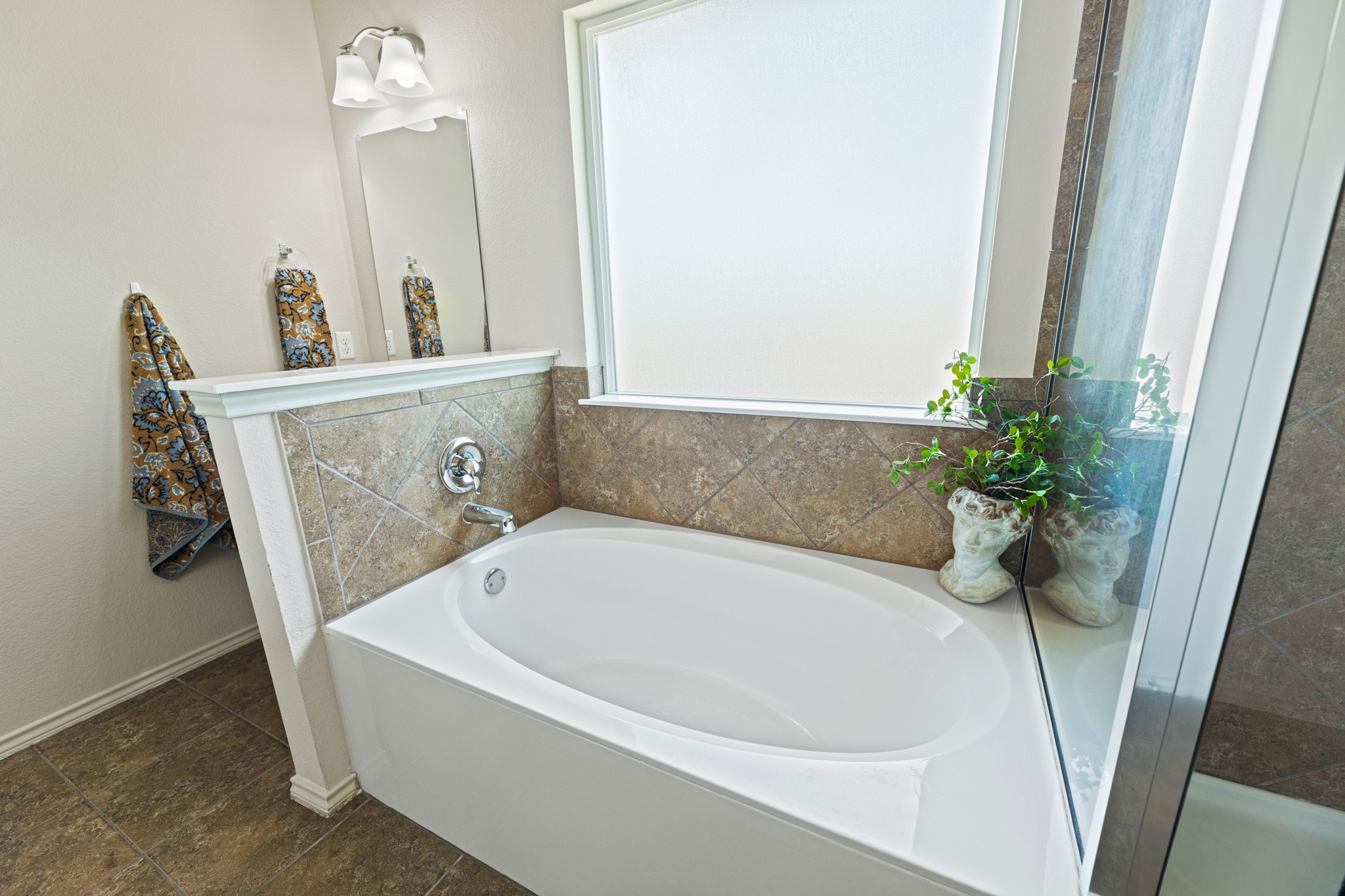 232 Geode Lane Jarrell, TX 76537 - Photo 21 of 39 The primary bathroom featuring tiled deep soaking tub set beneath a large frosted privacy window.