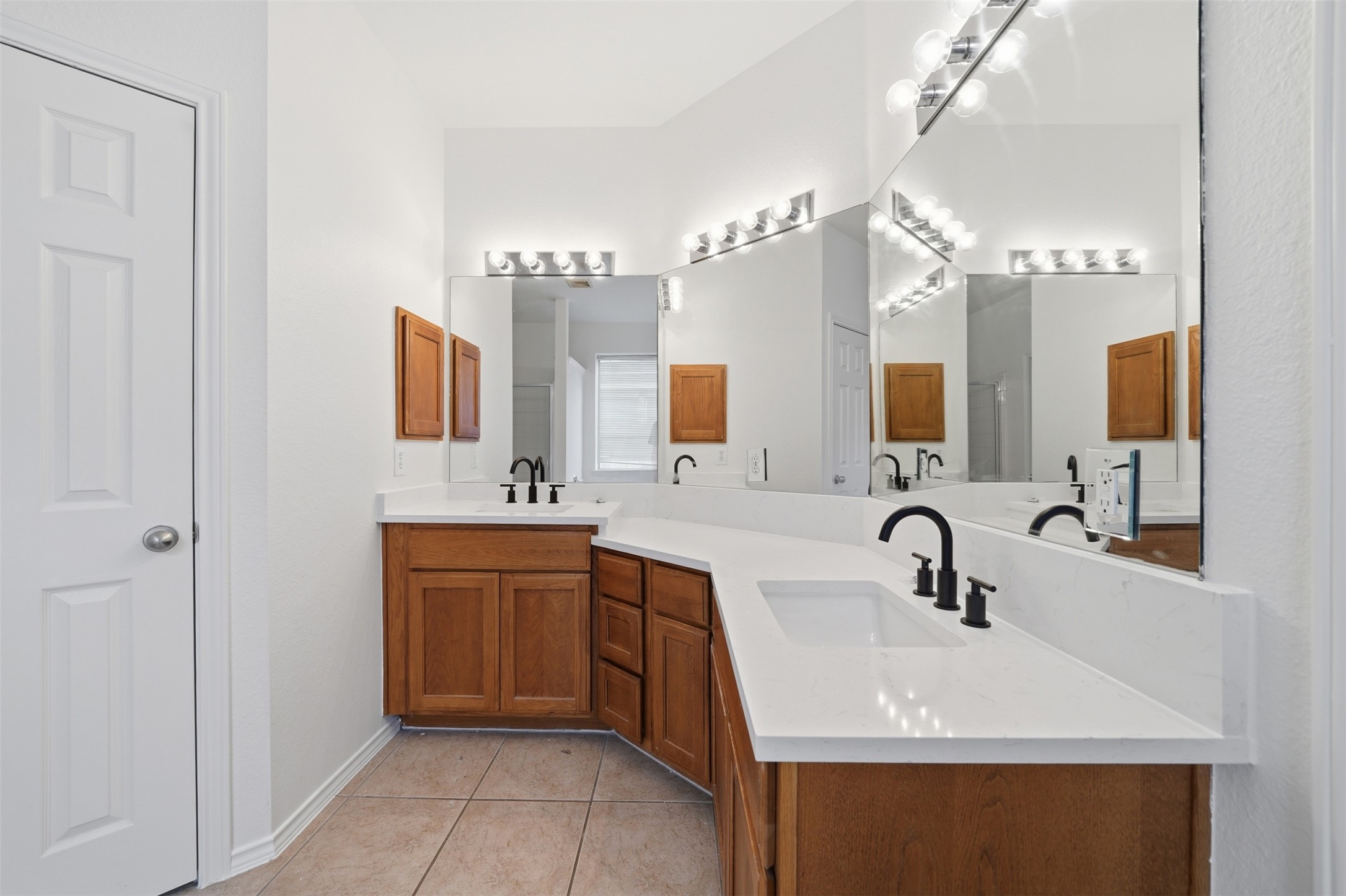 118 Invierno Street Kyle, TX 78640 - Photo 29 of 37 Double vanities with sleek countertops and dark fixtures adorn this well-appointed bathroom.