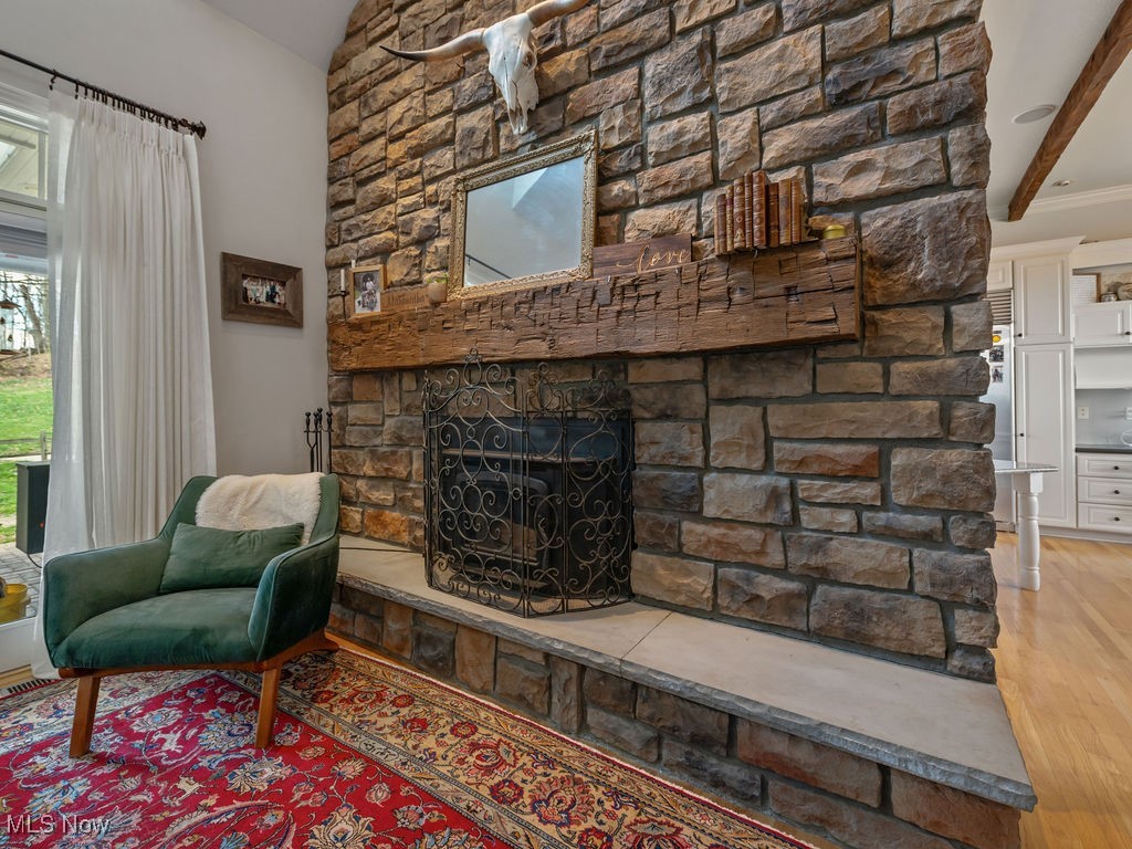 469 Vincent Hill Road Cairo, WV 26337 - Photo 9 of 48 Living room with lofted ceiling with beams, a stone fireplace, and wood finished floors
