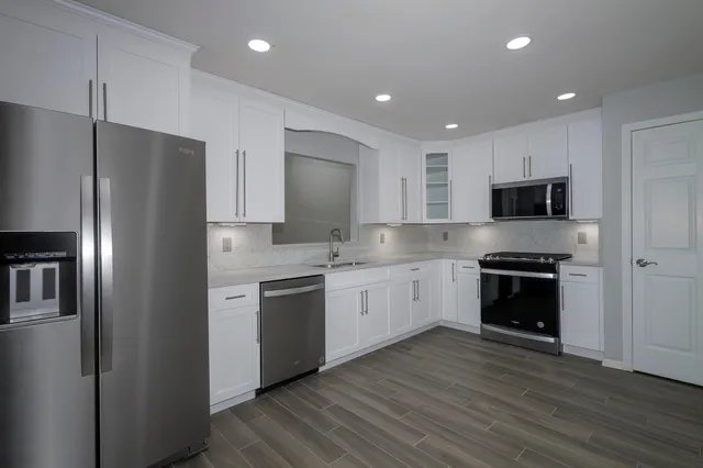 a kitchen with stainless steel appliances granite countertop a refrigerator oven a sink and dishwasher