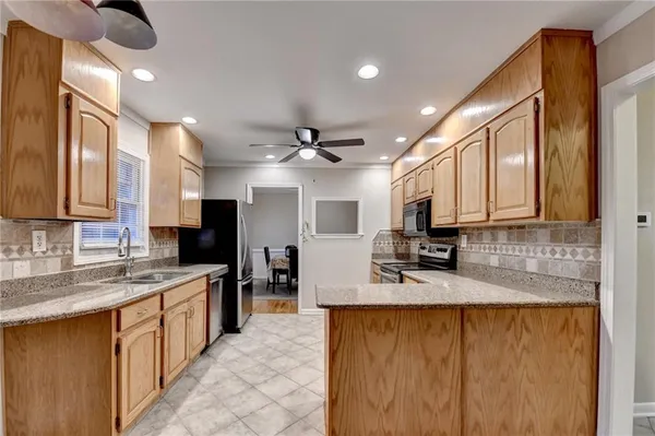 a kitchen with stainless steel appliances granite countertop a sink stove and refrigerator