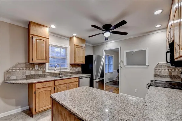 a kitchen with stainless steel appliances granite countertop a sink a stove and a refrigerator