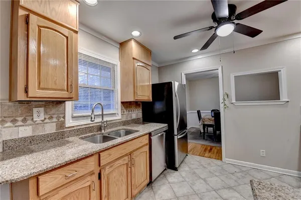 a kitchen with stainless steel appliances granite countertop a sink dishwasher stove top oven and refrigerator