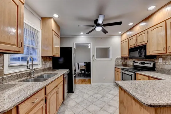 a kitchen with stainless steel appliances granite countertop a refrigerator and a stove top oven