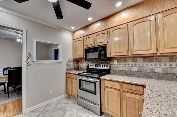 a kitchen with stainless steel appliances granite countertop a stove and a white cabinets