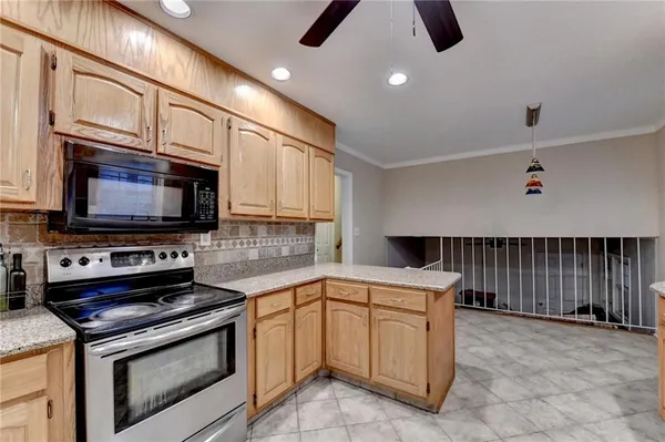 a kitchen with stainless steel appliances granite countertop a refrigerator a stove a sink and a microwave