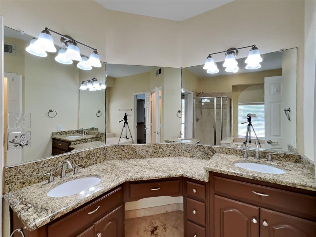 10805 Winged Foot Drive Rowlett, TX 75089 - Photo 12 of 26 a bathroom with a granite countertop double vanity sink and a mirror