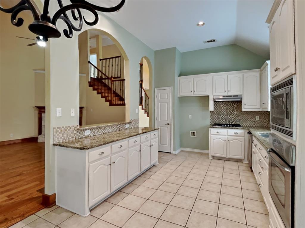 10805 Winged Foot Drive Rowlett, TX 75089 - Photo 7 of 26 a kitchen with stainless steel appliances granite countertop a stove a sink and a refrigerator