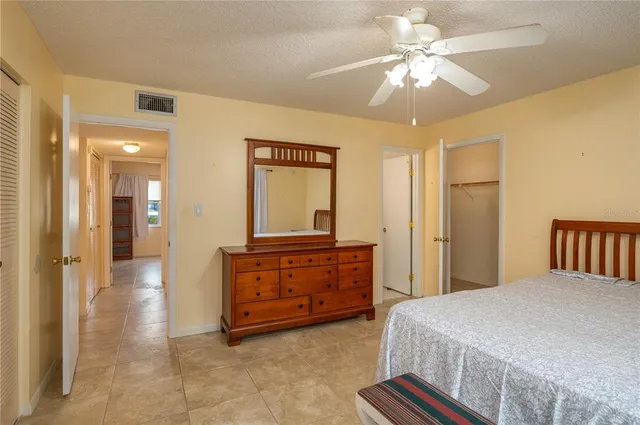 a spacious bedroom with a bed and a chandelier