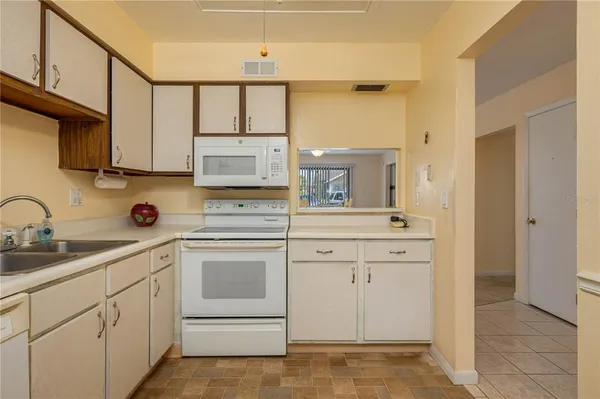 a kitchen with white cabinets and white appliances