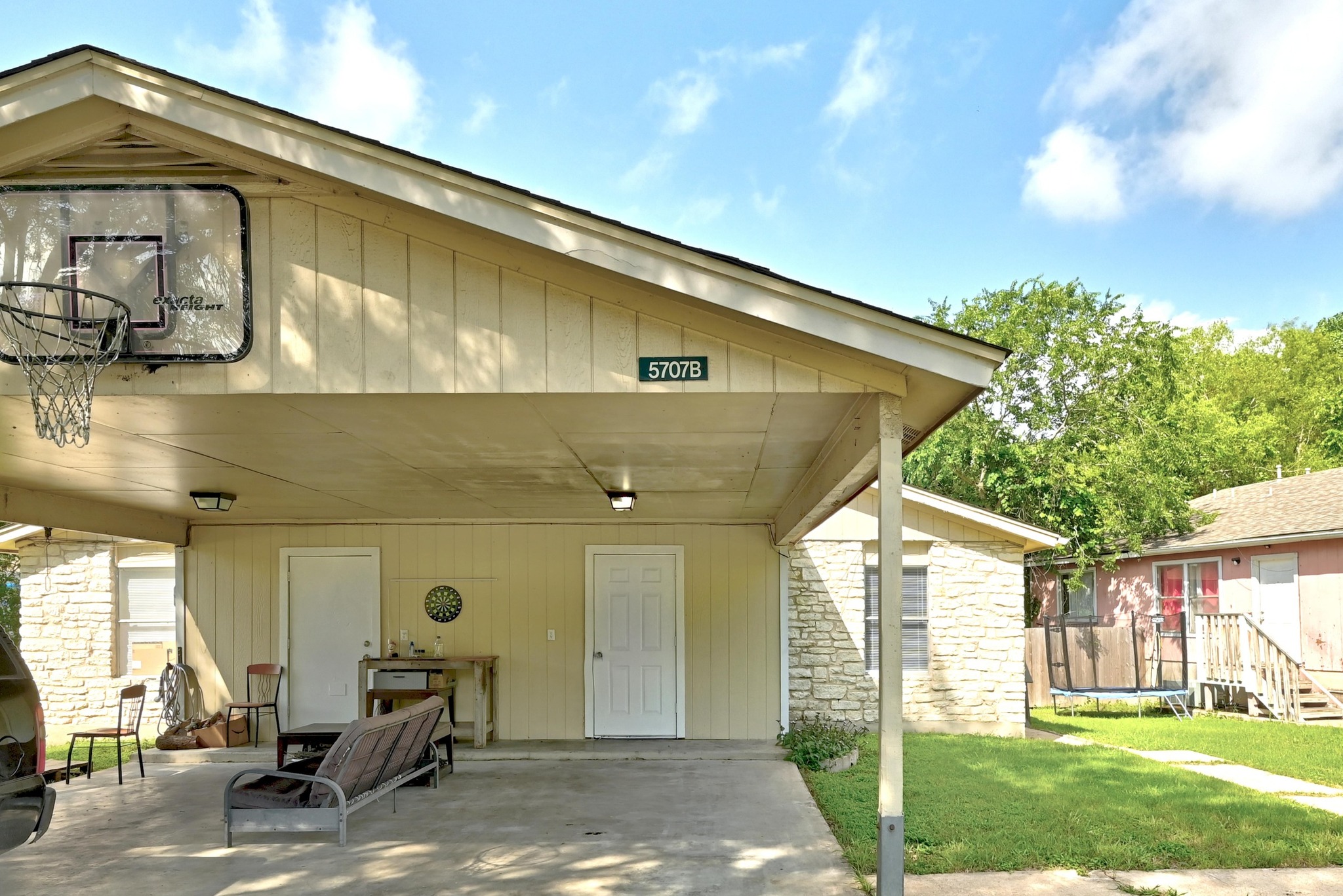 5707 Spring Meadow Road Austin, TX 78744 - Photo 2 of 21 a backyard of a house with table and chairs