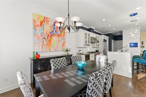 a living room with furniture a dining table and a chandelier