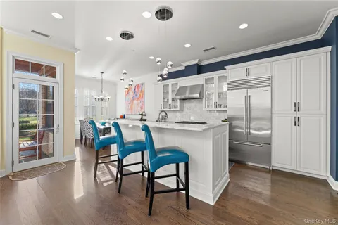 a kitchen with kitchen island a dining table chairs stainless steel appliances and cabinets