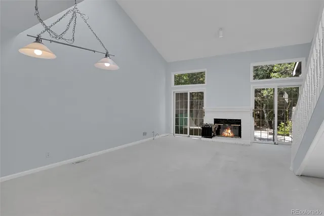 a view of an empty room with fireplace and a window