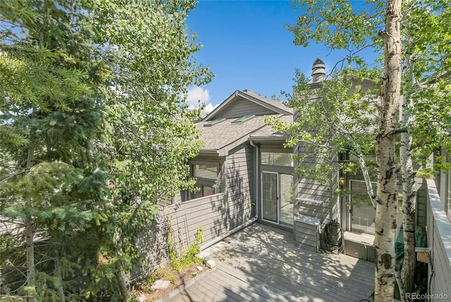 a view of a wooden house with a tree