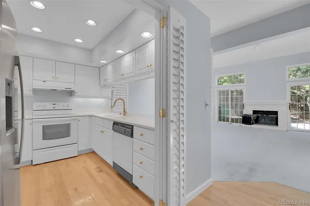 a kitchen with white cabinets and stainless steel appliances