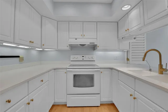 a kitchen with granite countertop white cabinets and white appliances