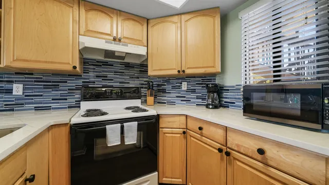 a kitchen with stainless steel appliances granite countertop a stove a sink and a microwave