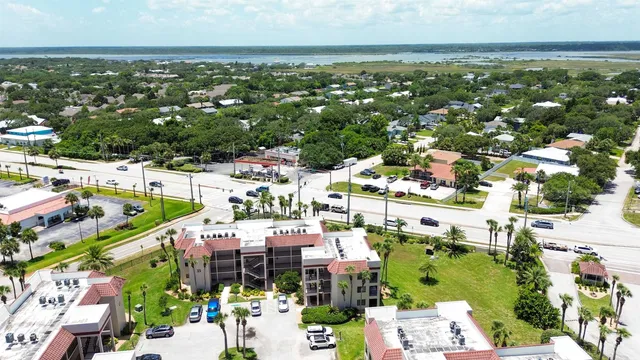 an aerial view of a city with lots of residential buildings ocean and mountain view in back