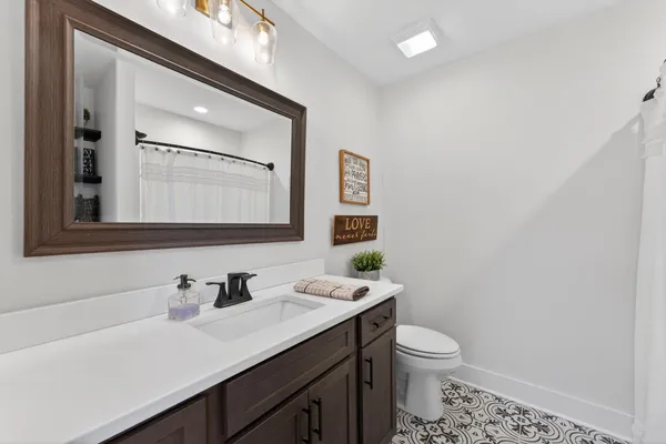 a bathroom with a granite countertop toilet sink and mirror