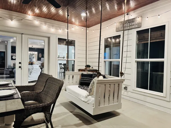 a living room with furniture a flat screen tv and chairs