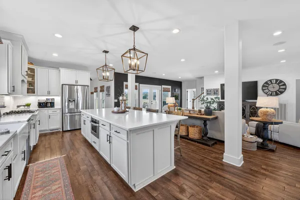 a large kitchen with stainless steel appliances kitchen island granite countertop a large island in the center